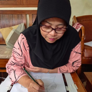 Ibu Dadah drawing out their final design with a pencil