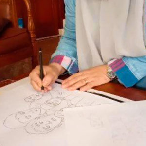 Ibu Quodar drawing out their final design with a pencil