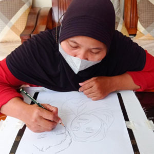 Ibu Dahlia drawing out their final design with a pencil