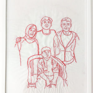 Ibu Mariah's final framed embroidery of her family. There are four figures, a man and a woman and two boys, one standing between the parents and the younger boy sitting on a chair in front of everyone.