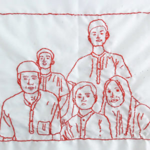 Ibu Marini's final embroidery of her family. There are five figures, a man and a woman and three children sitting close to each other with small smiles.